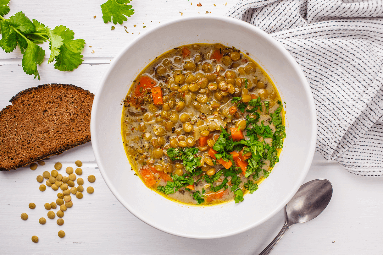 homemade-vegan-lentil-soup-with-vegetables-bread-cilantro-white-wooden-background