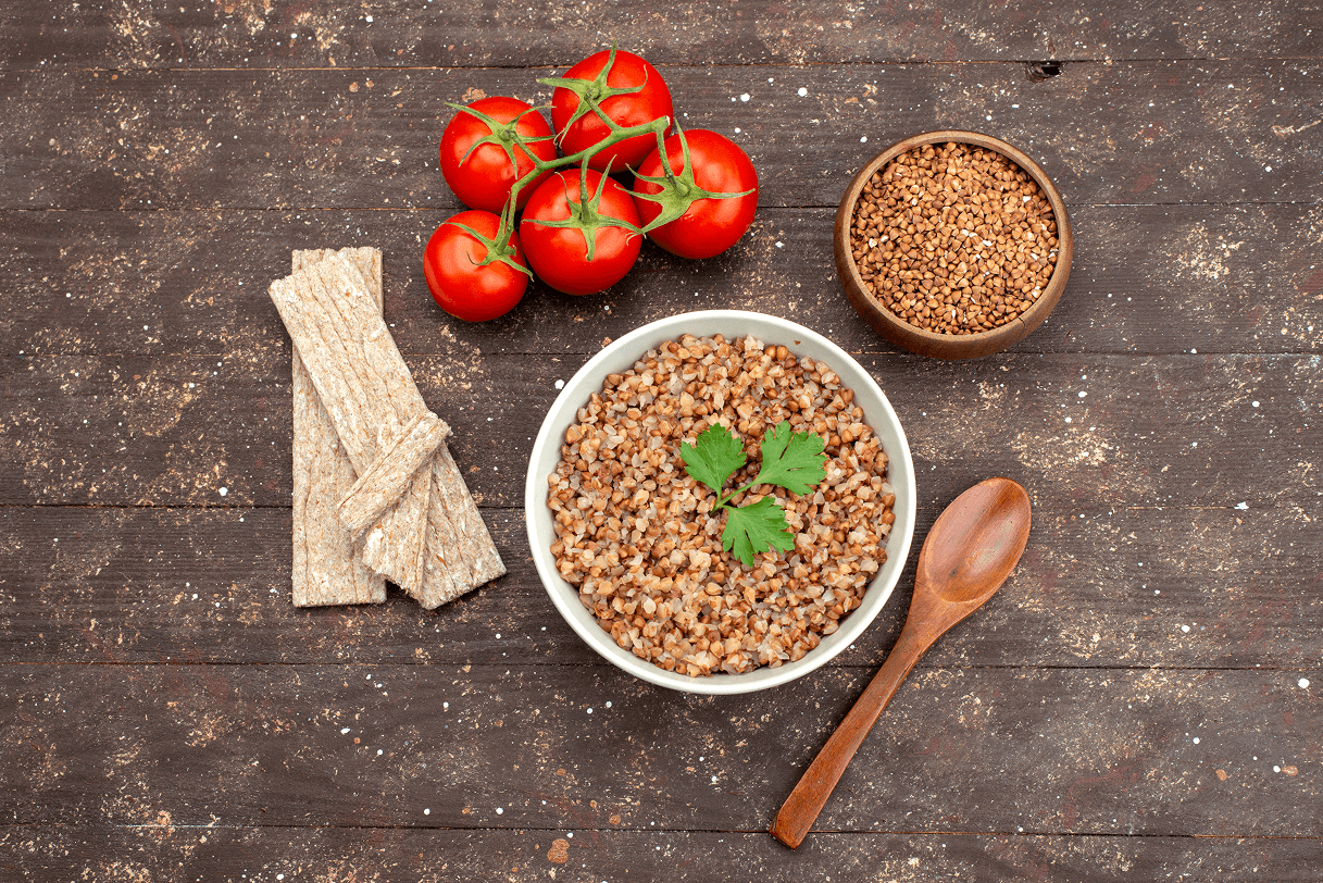 top-view-cooked-tasty-buckwheat-inside-plate-with-crisps-red-tomatoes-dark 1